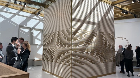 Eine Art Würfel mit vielen Namen steht in der Mitte eines Raumes, Menschen gehen darum herum. Das neue NS-Dokuzentrum in Freiburg ist am Donnerstag eröffnet worden.