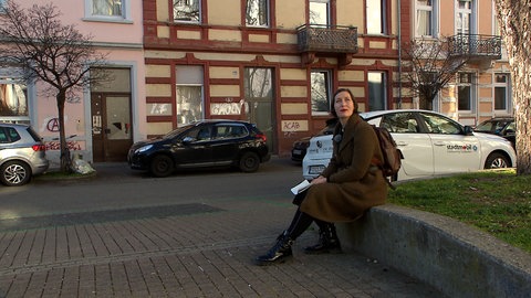 Valerie Tabea Schult sitzt auf einer Mauer im Freiburger Stadtteil Stühlinger.