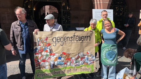 Menschen demonstrieren vor dem Freiburger Rathaus für und gegen die Verpackungssteuer