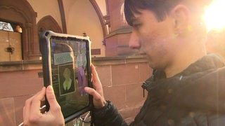 Jugendlicher schaut auf den Bildschirm seines Tablets