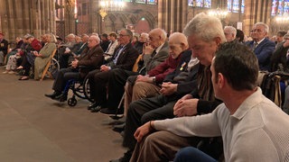 Mit gesenktem Kopf sitzen alte Männer im Straßburger Münster. Als sie jung waren, sind sie von den Nationalsozialisten unter Zwang eingezogen worden. Lange galten sie in Frankreich als Verräter. Jetzt wurden sie geehrt.