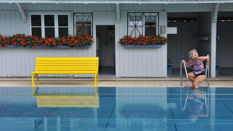 Eine Frau steigt im Freiburger Lorettobad ins Schwimmbecken.