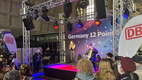 Abor & Tynna machen am Bahnhof in Basel ein Konzert auf einer Bühne.