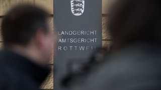 Ein Schild weist am Eingang darauf hin, dass sich in dem Gebäude das Land- und Amtsgericht Rottweil befindet. 