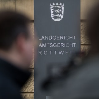 Ein Schild weist am Eingang darauf hin, dass sich in dem Gebäude das Land- und Amtsgericht Rottweil befindet. 