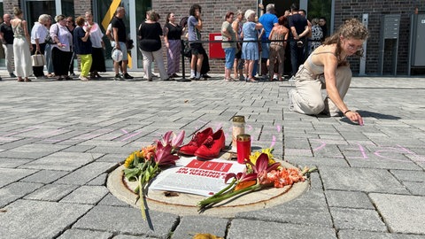Aktivisten haben in Gedenken an die getötete Frau aus Simonswald rote Schuhe, Blumen und Kerzen vor das Freiburger Landgericht gelegt.