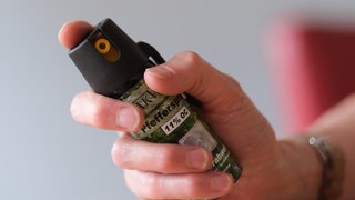 Eine Hand hält eine Kartusche mit Pfefferspray.