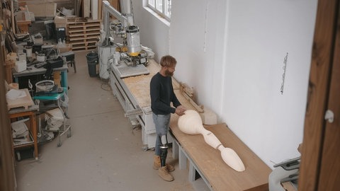 Ein Mann stellt eine Beinprothese her.