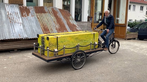 Bestattungsraderfinder Michael Olsen aus Oldenburg zeigt, wie ein Sarg per Rad zur letzten Ruhestätte transportiert werden kann