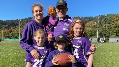 Eine Familie im lila Dress der Football-Mannschaft Freiburg Sacristans