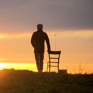 Ein Mann schaut in den Sonnenuntergang