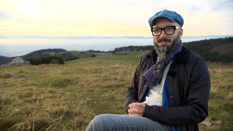 Ein Mann sitzt auf einem Stuhl