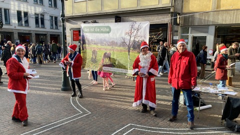 Mit Weihnachtsmann-Kostüm und Plätzchen machen Demonstranten in der Freiburger Innenstadt auf ein Neubauprojekt in Freiburg-Zähringen aufmerksam.
