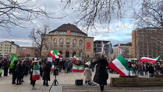 Demonstrierende mit Iran-Flaggen vor dem Freiburger Theater