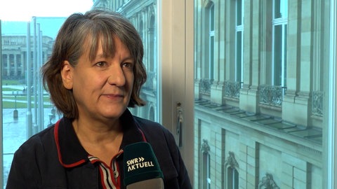 Eine Frau steht vor einem SWR-Mikrofon.