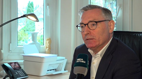 Ein Mann spricht in ein SWR-Mikrofon.