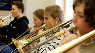 Schülerinnen und Schüler der Bigband spielen Posaune