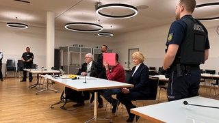 Der Angeklagte zu Prozessbeginn im Gerichtssaal des Freiburger Landgerichts. Er verbirgt sein Gesicht hinter einer roten Mappe