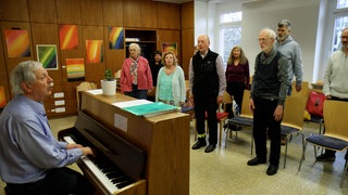 Menschen mit und ohne Demenz singen zusammen in einem Chor in Freiburg.