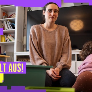 Mutter mit Kind sitzt im Wohnzimmer