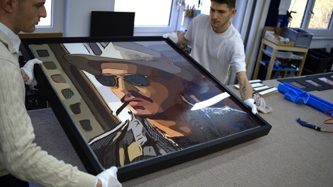 Johnny Depps gerahmtes Selbstportrait wird vorsichtig von Mitarbeitern der Emmendinger Galerie Queens transportiert.
