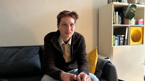 Nikolas Stegen sitzt auf dem Sofa in der zentralen Beratungsstelle für Weltanschauungsfragen Baden-Württemberg. 