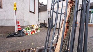Ein Baum und ein Gitter, die durch einen LKW beschädigt wurden, sind an der Unglücksstelle in Schramberg zu sehen. Nach dem tödlichen Unfall in Schramberg laufen jetzt Ermittlungen gegen den Lkw-Fahrer wegen fahrlässiger Tötung.