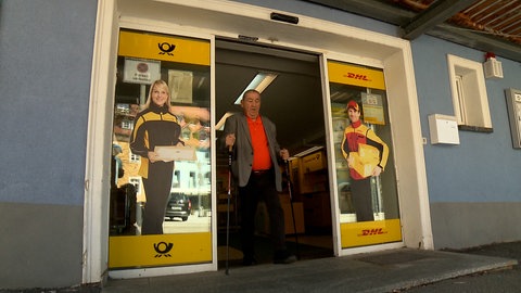 Ein Mann kommt aus einer Postfiliale.