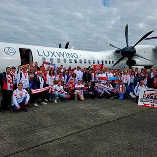 Fußballfan-Gruppenfoto vor einer Propellermaschine