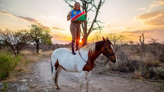 Nadine Schäfers steht auf einem Pferd. 