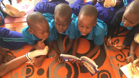 Kinder an der inklusiven Schule Zinunula liegen auf einem Teppich und lesen sich aus Büchern vor. Für Ursula Heinemann aus Mähringen ein besonderer Moment.