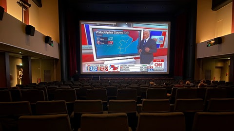 Menschen sitzen im Kinosaal und sehen sich die Übertragung des Senders CNN auf der Leinwand an, um die Wahl in den USA zu verfolgen.