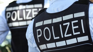 Die Aufschrift "Polizei" ist auf der Uniform von Polizisten zu sehen.