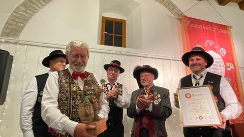 Werner Mezger hält die Goldene Saubloder in Händen. Rechts neben ihm stehen Jochen Fundel von der Vereinigung Freier Oberschwäbischer Narrenzünfte, Laudator Roland Wehrle und Reinhard Siegle, der Präsident der Vereinigung Freier Oberschwäbischer Narrenzünfte. Links von Mezger steht Vizepräsident Jörg Ritter.