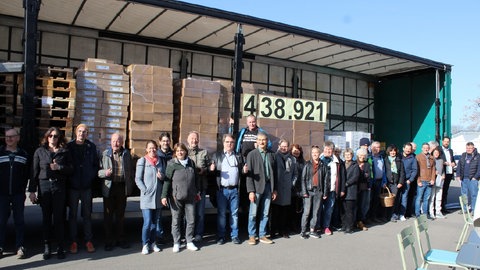 Eine Menschengruppe steht vor einem Lastwagen, dessen Ladefläche einsehbar ist. Daruf die Zahl 438.921 - so viele Stellungnahmen haben Bürgerinitiativen gegen die Pläne zur Windkraft des Regionalverbands nach eigenen Angaben gesammelt.