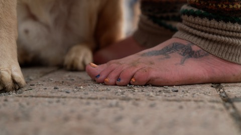 Matthias Bonn lackiert sich die Fußnägel, damit die nackten Füße noch mehr auffallen.