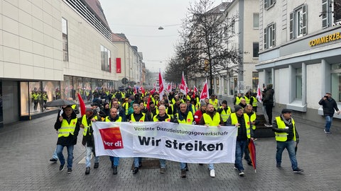 Demonstrierende von Verdi ziehen mit einem Protestplakat durch Tübingen. Die Gewerkschaft hat unter anderem Busfahrer und Kita-Beschäftigte zum Streik aufgerufen.