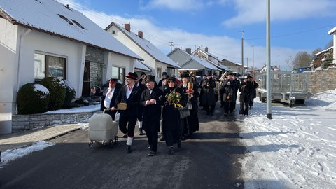 Verkleidete Schauspieler ziehen durch den Ort
