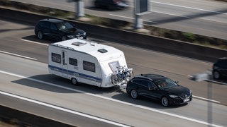 Geklaut? Ein Auto mit einem Wohnwagen fährt auf der Autobahn