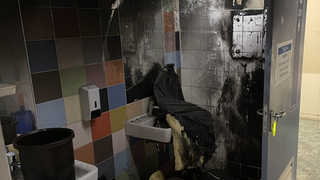 Symbolbild: Eine Schultoilette nach einem Brand. Die Kacheln und das Waschbecken sind verrust.