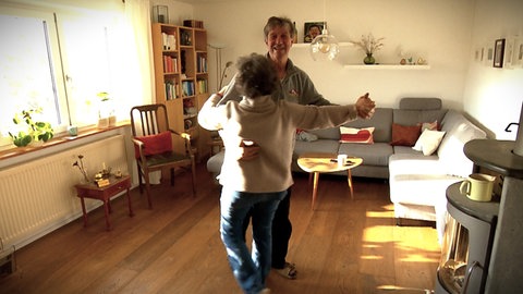 Das Ehepaar tanzt Walzer im Wohnzimmer in Zwiefalten, der Partnerstadt von La Tessoualle. Die beiden haben sich über den deutsch-französischen Schüleraustausch kennengelernt.