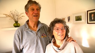 Uschi und Luc Chupin stehen in ihrem Wohnzimmer in Zwiefalten Arm in Arm: Wie aus einem Schüleraustausch eine Liebe bis heute wurde.