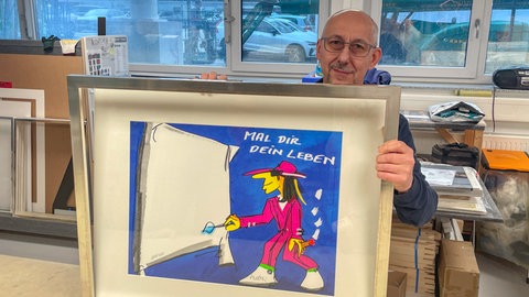 Jaero Carpes rahmt ein Bild für die Ausstellung Panik in Tübingen, Bilder von Udo Lindenberg, im neuen Kunstmuseum.