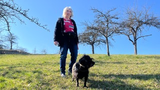 Die Hündin Bonnie und ihre Halterin sind auf einer grünen Wiese vor blauem Himmel bei Rottenburg-Oberndorf zu sehen. Dort wurde die Hündin von Schäferhunden gebissen.