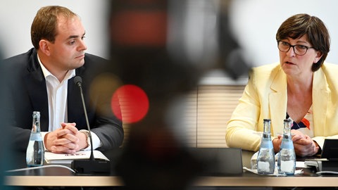 Bei einer Pressekonferenz optisch durch einen unscharfen Gegenstand im Vordergrund getrennt, aber oft einer Meinung: Florian Kling und Saskia Esken