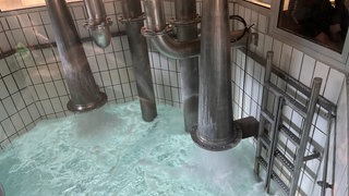 Aus riesigen Rohren strömt leuchtend blaues Wasser in ein großes Auffangbecken. Hier wird das Trinkwasser gemischt.
