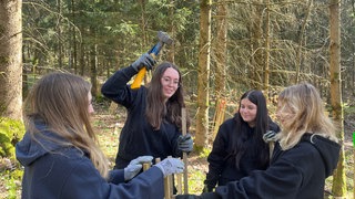 Schülerinnen und Schüler pflanzen Tannensetzlinge im Wald auf der Schwäbischen Alb.