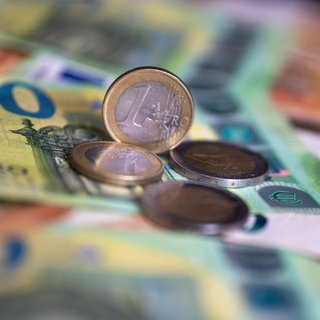 Münzen liegen auf Geldscheinen. Tübinger Haushalt nicht genehmigt. Das Regierungspräsidium fordert Nachbesserungen.