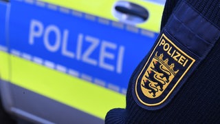 Ein Polizeiauto und ein Polizei-Abzeichen sind zu sehen. Die Polizei hat ein Obduktionsergebnis zu einem toten Baby in Albstadt mitgeteilt.
