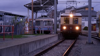 Eine alte E-Lok fährt in der Dämmerung am Bahnhof ein. Das Trossinger Eisenbahnmuseum veranstaltet einmal im Monat eine Mondscheinfahrt.